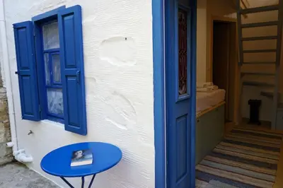 a blue table next to a wall with a blue window at Caza Rina Appartment, Symi in Symi