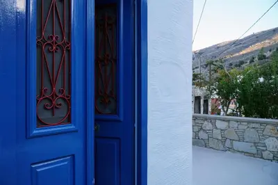a blue door with a view of a hill at Caza Rina Appartment, Symi in Symi