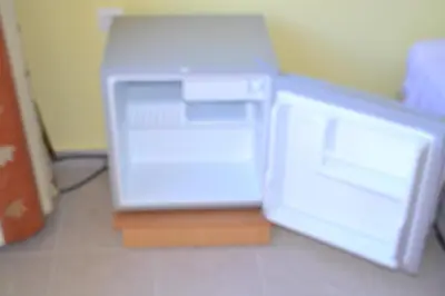 a small white refrigerator sitting on the floor at To Akrogiali in Phanaes