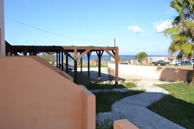 a view of a beach with a wooden pergola at To Akrogiali in Phanaes