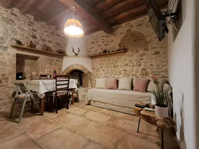a living room with a couch and a table at Thelya - Stone House in Apóllona