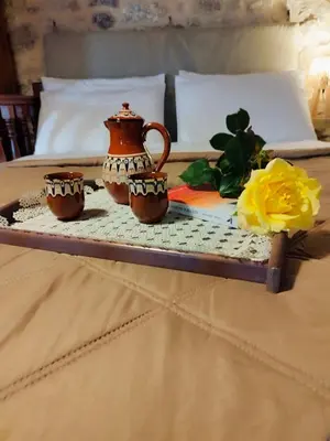 a tray with two cups on top of a bed at Thelya - Stone House in Apóllona