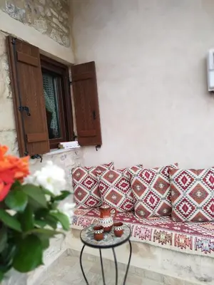 a couch with pillows and a table in a room at Thelya - Stone House in Apóllona