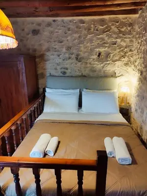 a bedroom with a bed with two towels on it at Thelya - Stone House in Apóllona