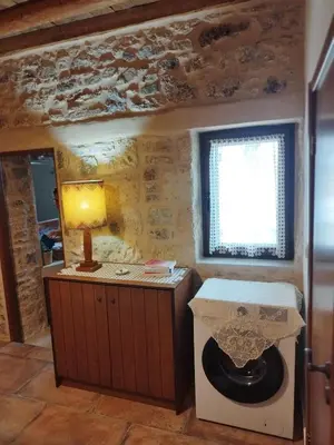 a bathroom with a toilet and a lamp in a room at Thelya - Stone House in Apóllona