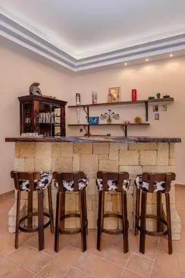 a bar with four stools in front of it at Coral Tree Luxury Villa in Ialyssos