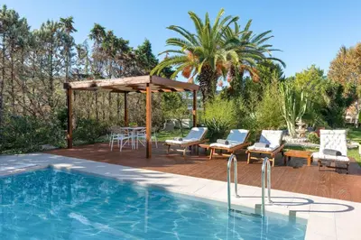 a pool with a gazebo and a table and chairs at Coral Tree Luxury Villa in Ialyssos