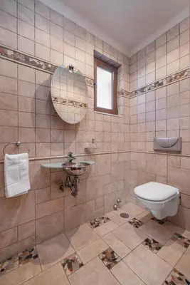 a tiled bathroom with a toilet and a sink at Coral Tree Luxury Villa in Ialyssos