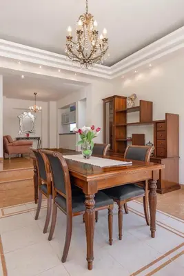 a dining room table with chairs and a chandelier at Coral Tree Luxury Villa in Ialyssos