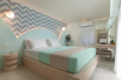 a bedroom with a large bed and a desk at Ελin Villa in Kalathos