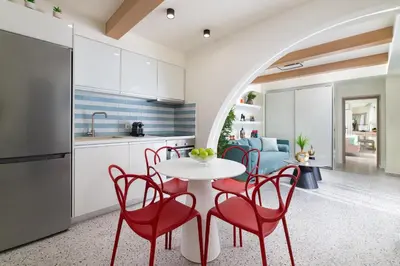 a kitchen and dining room with red chairs and a table at Ελin Villa in Kalathos