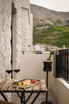 a table with a plate of food and a glass of wine at Abella Suites Embonas in Émbonas
