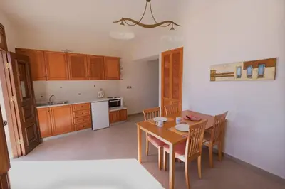 a kitchen with a table and chairs in a room at Harbour View Modern Apartments with Terrace in Halki