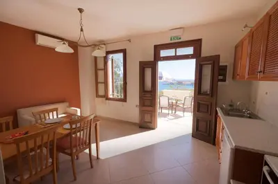 a kitchen with a table and a dining room with a view at Harbour View Modern Apartments with Terrace in Halki