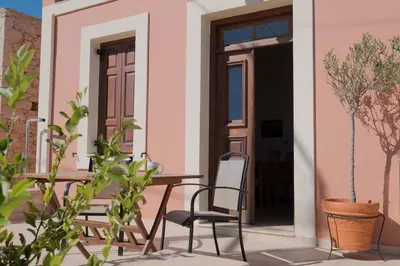 a patio with a table and chairs in front of a house at Harbour View Modern Apartments with Terrace in Halki