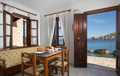 a dining room with a table and a view of the ocean at Charming Waterfront Studio with swimming access in Halki