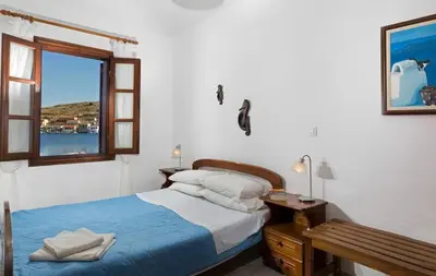 a bedroom with a bed and a window at Charming Waterfront Studio with swimming access in Halki