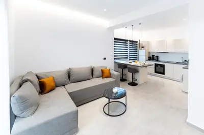 a living room with a couch and a kitchen at Alter Ego Cozy Corner in Rhodes Town