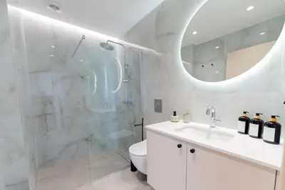 a white bathroom with a shower and a sink at Alter Ego Cozy Corner in Rhodes Town