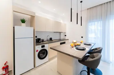 a kitchen with a refrigerator and a table with chairs at Alter Ego Cozy Corner in Rhodes Town