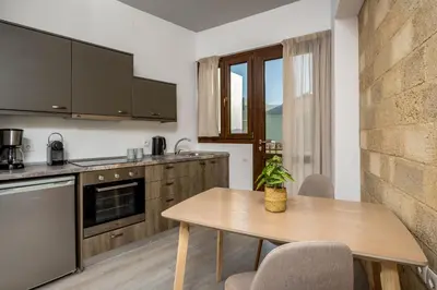 a kitchen with a wooden table and a table and chairs at Mulberry Apartments in Rhodes Town