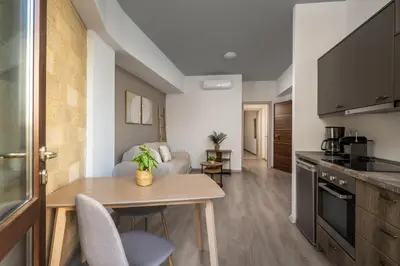 a kitchen and living room with a table and chairs at Mulberry Apartments in Rhodes Town