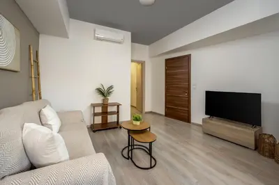 a living room with a couch and a flat screen tv at Mulberry Apartments in Rhodes Town