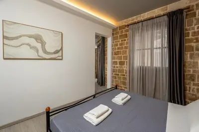 a bedroom with a bed with two white towels on it at Mulberry Apartments in Rhodes Town