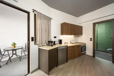 a kitchen with a sink and a table in a room at Mulberry Apartments in Rhodes Town