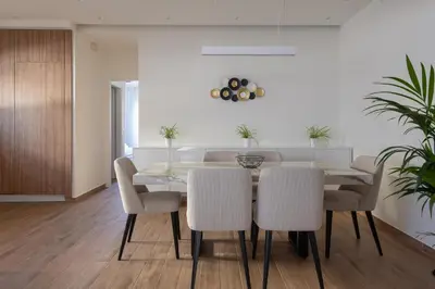a dining room with a glass table and white chairs at Onirico Apartment in Rhodes Town