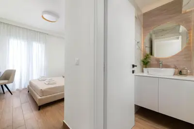 a white bathroom with a sink and a bed at Onirico Apartment in Rhodes Town