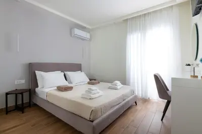 a white bedroom with a bed with towels on it at Onirico Apartment in Rhodes Town