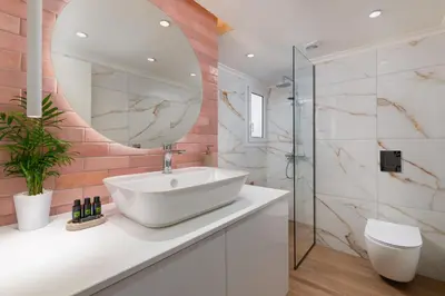 a bathroom with a white sink and a mirror at Onirico Apartment in Rhodes Town