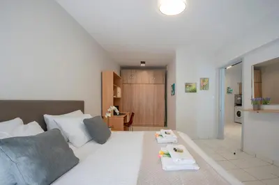 a bedroom with a white bed with two trays on it at Sunwaves City Center Apartment in Rhodes Town