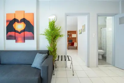 a living room with a blue couch and a plant at Sunwaves City Center Apartment in Rhodes Town