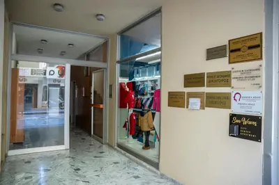 a store entrance with glass doors and signs on the wall at Sunwaves City Center Apartment in Rhodes Town