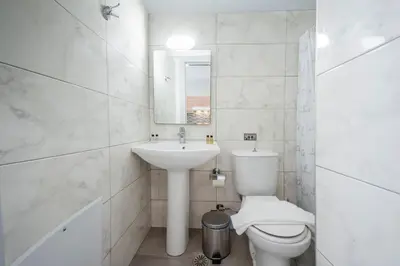 a white bathroom with a toilet and a sink at Sunwaves City Center Apartment in Rhodes Town
