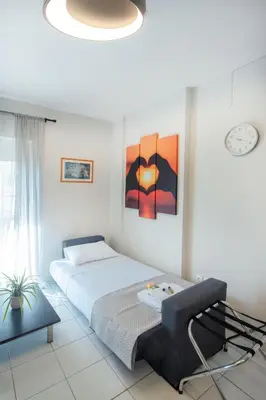 a bedroom with a bed and a painting on the wall at Sunwaves City Center Apartment in Rhodes Town