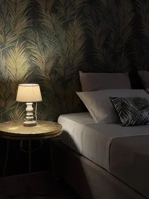 a bedroom with a bed and a table with a lamp at Casa Assisi in Rhodes Town