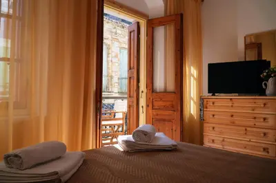 a bedroom with a bed and a television and a window at Antoni's Symi Home in Symi