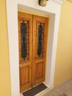 a large wooden door in a room at Antoni's Symi Home in Symi