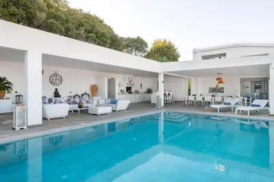 a swimming pool with blue water in a house at Luxury Villa Oceania Lindos with Private Infinity Pool in Líndos