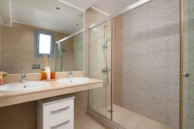 a bathroom with two sinks and a shower at Luxury Villa Oceania Lindos with Private Infinity Pool in Líndos