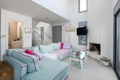 a living room with a blue couch and pink pillows at Luxury Villa Oceania Lindos with Private Infinity Pool in Líndos