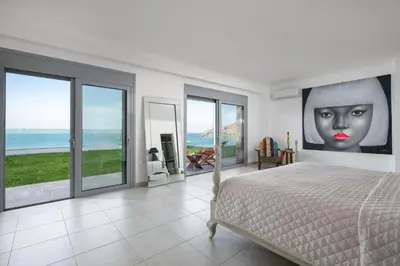 a bedroom with a bed and a painting of a woman at Luxury Villa Oceania Lindos with Private Infinity Pool in Líndos