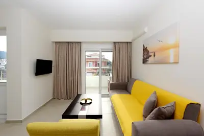 a living room with a yellow couch and a table at Elli Garden View in Kremasti