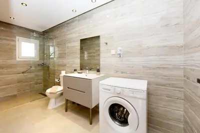 a bathroom with a washing machine and a toilet at Elli Garden View in Kremasti