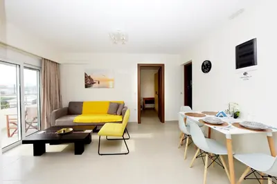 a living room with a couch and a table at Elli Garden View in Kremasti