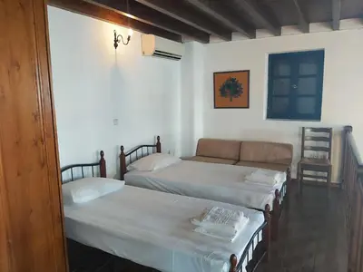 a bedroom with two beds and a couch in it at Litsa Holiday Home in Kalathos