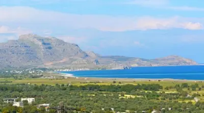 a view of a large body of water and a mountain at Litsa Holiday Home in Kalathos